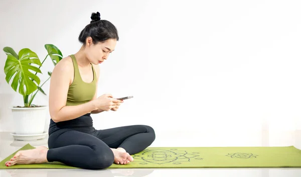 Жінки Грають Мобільному Телефоні Сидять Зеленому Килимку Йоги Відпочиваючи Занять — стокове фото