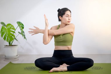 Kadınlar evde meditasyon yapmak ve egzersiz yapmak için yeşil yoga minderinde yoga yaparlar..