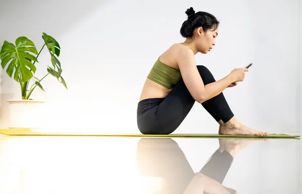 Жінки Грають Мобільному Телефоні Сидять Зеленому Килимку Йоги Відпочиваючи Занять — стокове фото