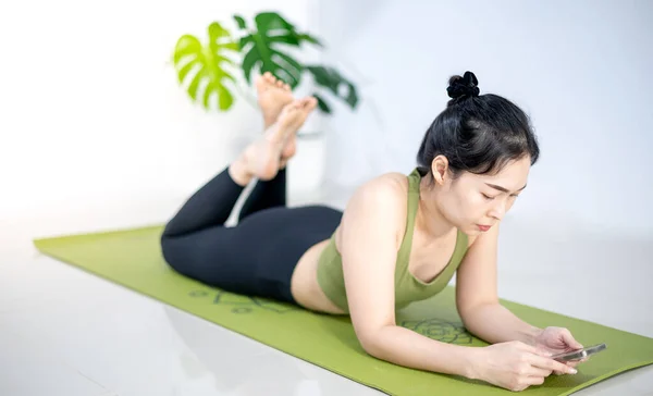 Las Mujeres Juegan Móvil Sientan Esterilla Yoga Verde Mientras Descansan — Foto de Stock