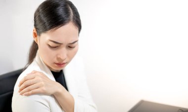 Asyalı gençler evlerinde dizüstü bilgisayarın önünde otururken işten dolayı acı çekiyorlar. Çalışan kadın ofis sendromu.