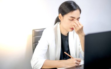 Asyalı gençler evlerinde dizüstü bilgisayarın önünde otururken işten dolayı stres yaşıyorlar. Stresli çalışan veya öğrenci kavramı çalışmaktan bıktı, çevrimiçi sorun hakkında endişelendi.