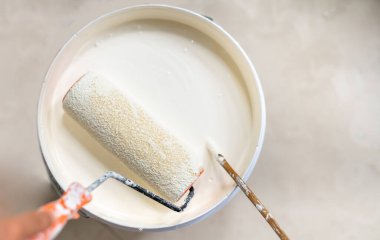 Kadın eli, ahşap çubuğu kullanarak tepsiye boya karıştırır ve yuvarlar.. 