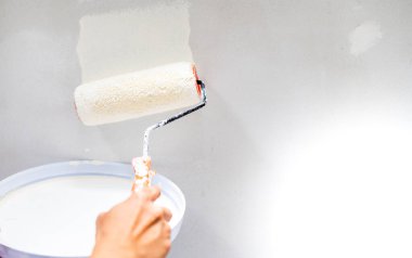 Kadın eli, koruma ve aşınma için paten fırçasıyla çelik yüzey duvarında paten fırçası, fırça ve fırça kullanıyor..
