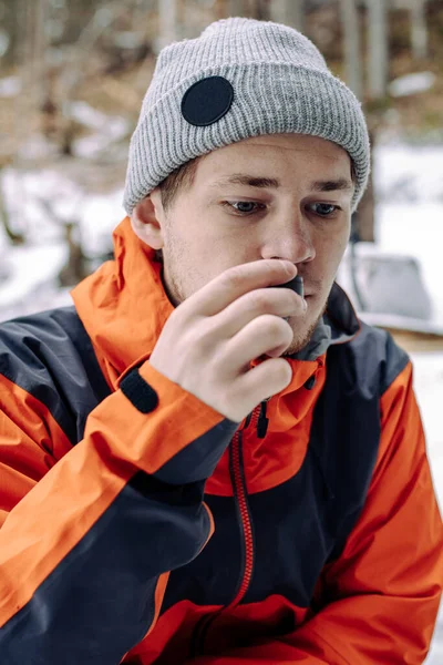 Ormanda sırt çantası ve termoslu bir adam var.