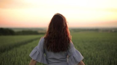 Genç ve güzel bir kız buğday tarlasında duruyor..