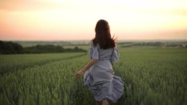 Gün doğumunda buğday kulaklı genç kadın