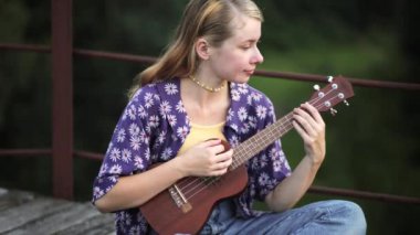 Gitarı ve kitabı olan güzel bir kız. bir yaz konsepti.