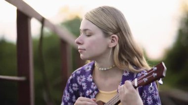 Akustik gitar çalan heyecanlı kız. İp enstrümanında akorlar çalan mutlu müzisyen. Olumlu gitarist şarkı söylerken kafasını hareket ettiriyor. Müzisyen gitarda beste yapıyor.