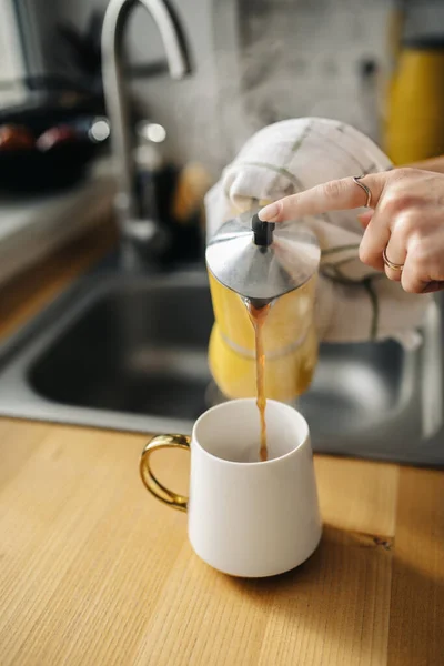 Kahve bardağına kahve dolduran barmen.