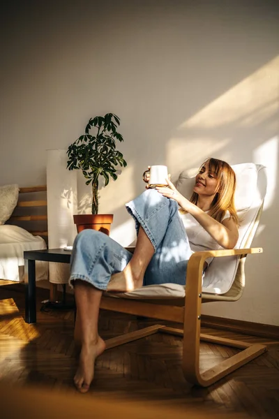 Kafedeki sandalyede oturan beyaz gömlekli ve mavi elbiseli güzel bir kadın.