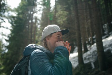 Sırt çantası ve arka planda bir şapkası olan genç bir kız Yahudi 'nin HARP' ını oynuyor.