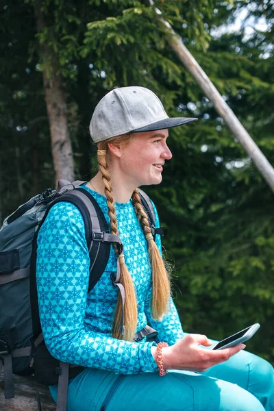 Sırt çantası ve şapkası olan genç bir kız sırtında yürüyor.