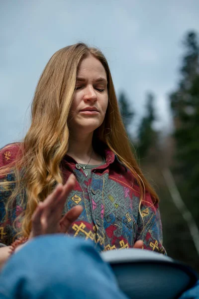 Genç bir kadın nehrin arka planında glukofon çalıyor.