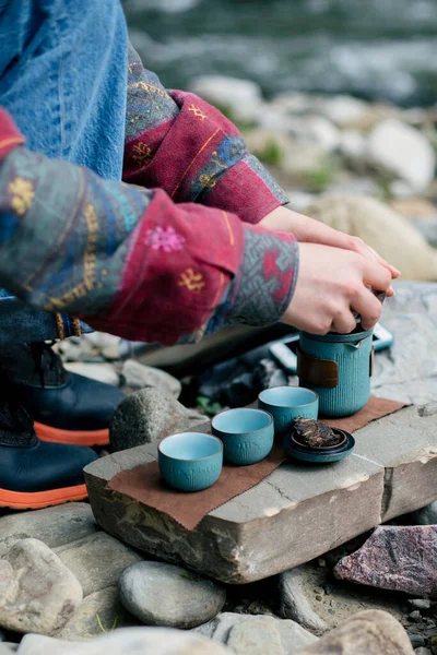 woman sitting on the beach with a cup of coffee