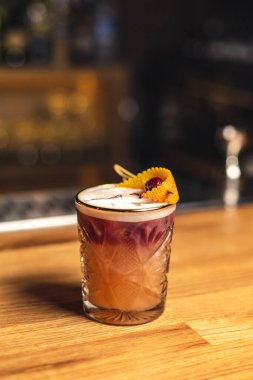 Tahta masada buz küpleri olan lezzetli bir kokteyl.