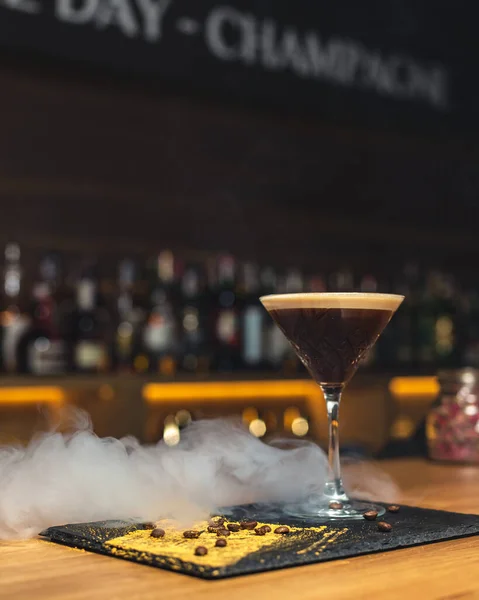 Bir bardak buzlu viski ve ahşap bir masada taze böğürtlen..