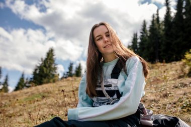 Sırt çantalı genç bir kadın dağların arkasında