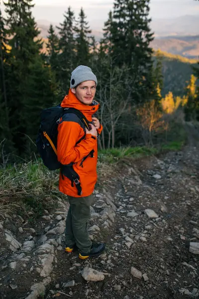 Sırt çantalı bir yürüyüşçü dağlarda yürüyüş yapıyor.