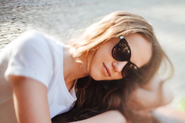 Güneş gözlüklü rahat genç bayan. Kahvenin terasında yaz siestası