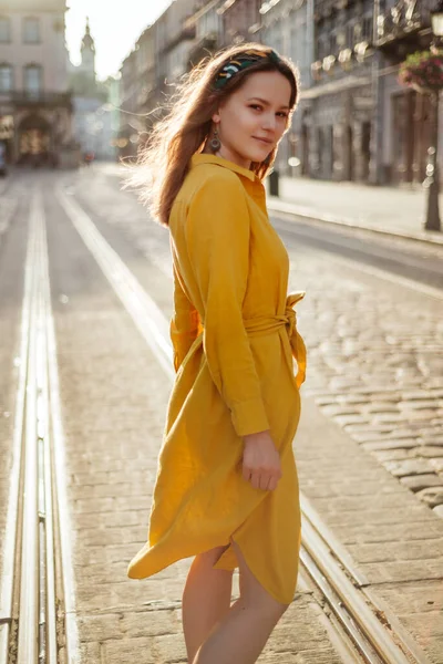 夏天的时尚 黄色衣服 穿着夏装的时髦姑娘走在旧城区的大街上 穿着金色紧身衣微笑的女人画像 — 图库照片
