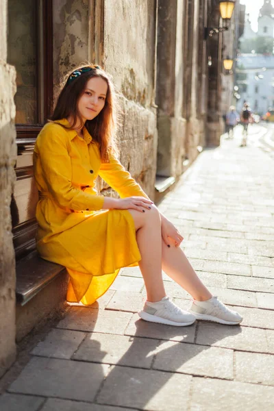 穿着夏装的漂亮女孩坐在旧城区街道上 年轻的欧洲女人夏天的黄色肖像 — 图库照片