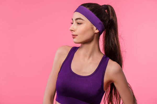 Studio portrait of fitness girl in sporty outfit on pink background. Sport, healthy lifestyle