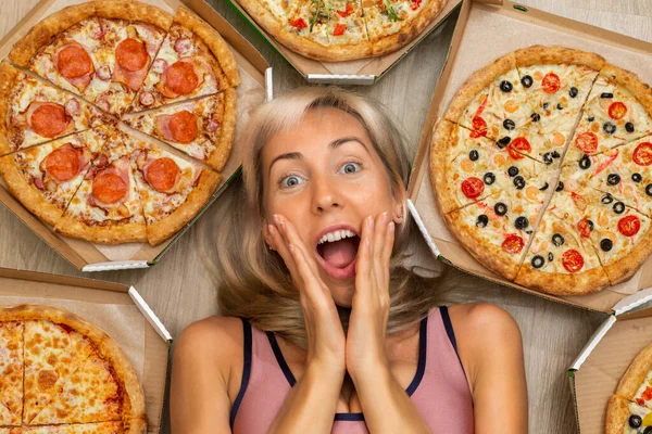 A young girl with blond hair in a pink tank top holds her face with her hands and screams with happiness. Colorful pizza
