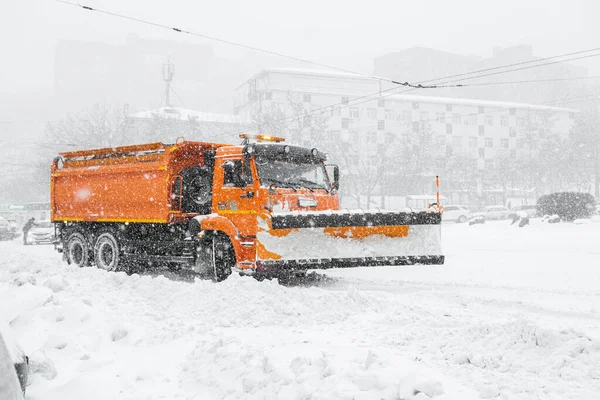 Kar kalkmadan önce büyük bir turuncu kar küreme aracı yolda duruyor. Kar temizleme hortumu için özel ekipman. — Stok fotoğraf
