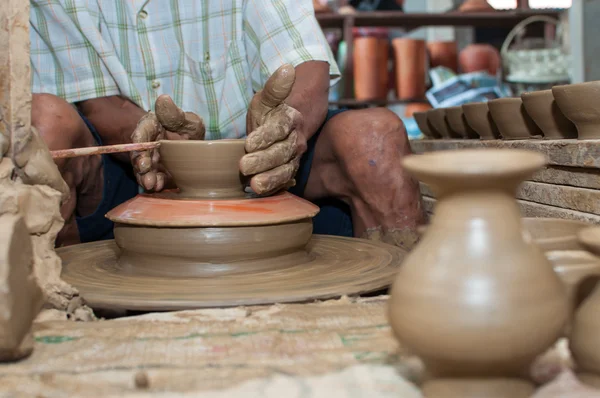 Un hombre da forma a la cerámica mientras gira en una rueda — Foto de Stock