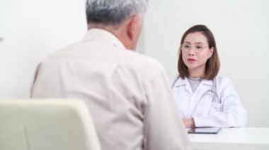 Asyalı Kadın Doktor, hastanedeki erkek hastayı, sağlık ve tıbbi konsepti inceliyor.