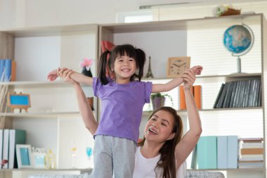 Anne evde kızıyla eğleniyor ve oynuyor, mutlu Asyalı çocuk, aile kavramı