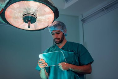 Ameliyathanede çalışan yakışıklı bir cerrahın portresi.