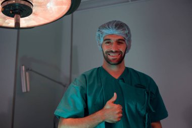 Yakışıklı doktor cerrahın portresi hastane koridorunda duruyor.