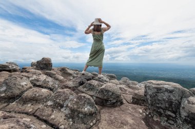 Young Asian women traveler hiking on mountains at Lan Hin Pum, Phu hin Rong Kla National Park, Phitsanulok province, Thailand