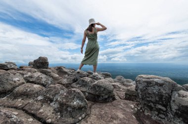 Young Asian women traveler hiking on mountains at Lan Hin Pum, Phu hin Rong Kla National Park, Phitsanulok province, Thailand