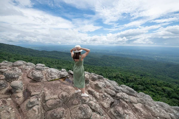 Young Asian women traveler hiking on mountains at Lan Hin Pum, Phu hin Rong Kla National Park, Phitsanulok province, Thailand
