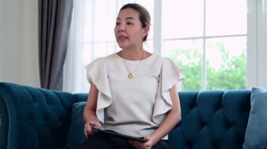 Stresli Asyalı kadın evde tabletle çalışmaktan yorgun ve çok düşünüyor.