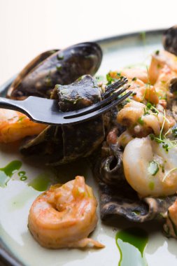 Karides, midye, mürekkep balığı ve ahtapotlu siyah deniz ürünleri makarnası.