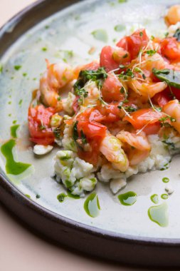 Yumurta ve karidesli omlet, yanında domates ve mikro yeşil.