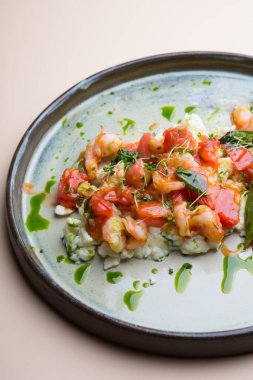 Yumurta ve karidesli omlet, yanında domates ve mikro yeşil.