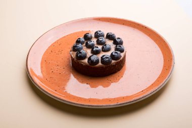 Bütün yuvarlak yaban mersinli turta bir tabakta servis edilir.