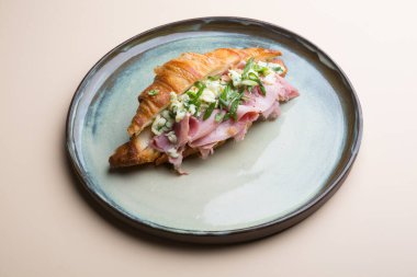 Dilimlenmiş jambon ve peynirle doldurulmuş taze kruvasan