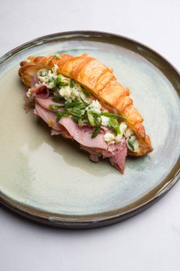 Dilimlenmiş jambon ve peynirle doldurulmuş taze kruvasan