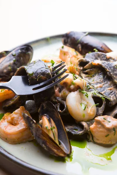 Karides, midye, mürekkep balığı ve ahtapotlu siyah deniz ürünleri makarnası.