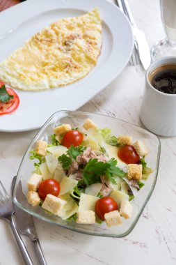 Sezar salatası ve yumurta omleti kahvaltıda bir kafede servis edilir.