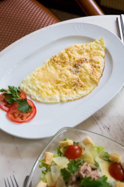 Sezar salatası ve yumurta omleti kahvaltıda bir kafede servis edilir.