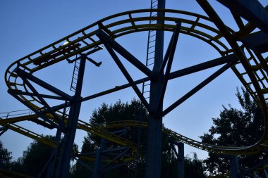 Eğlence siluetleri mavi gökyüzüne karşı parkta inşaat yapıyor.