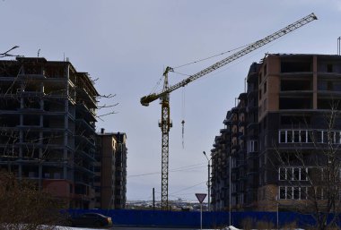 Gün batımında inşaat halindeki yüksek binalar arasındaki vinç görüntüsü