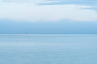 Deniz uyarı işareti. Bulutlu mavi minimalist deniz manzarası. Ufuk çizgisi olan terk edilmiş boşluk.